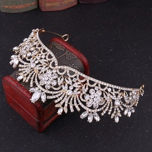 Détail d'un diadème de mariée doré serti de strass sur un coffret à bijoux rouge vintage