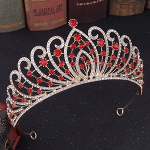 Close-up of golden Baroque crown with red rhinestones on vintage book background