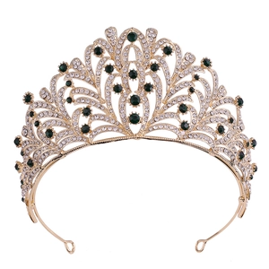 Detailed macro view of gold alloy bridal crown with green gems and leaf rhinestone inlay
