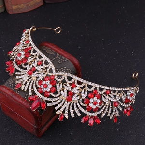 Vue détaillée d'une tiare fleurie dorée avec cristaux rouges sur un coffret à bijoux