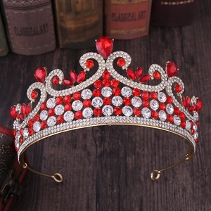 Détails d'un diadème de mariée doré avec cristaux rouges en forme de cœur et diamants