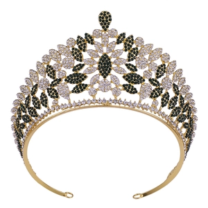 Exquisite gold bridal crown with deep green and white crystals in a floral leaf design
