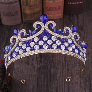Détail macro du diadème royal doré avec cristaux bleus sur bois vintage