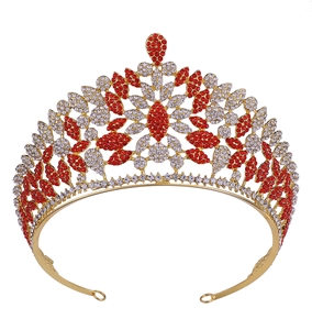 Detailed close-up of golden crown featuring red and clear rhinestones with floral pattern