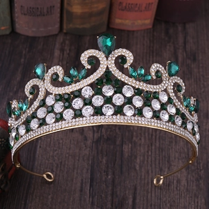 Détail d'une couronne de mariée vintage dorée avec gemmes vert émeraude et petits cristaux blancs