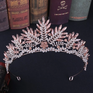 Close-up of rose gold bridal crown with pink crystals and rhinestones on vintage books