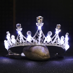 LED lit silver bridal crown with teardrop crystals and handmade pearls on a stone base