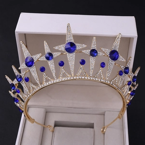 Macro view of gold bridal crown with blue gemstones and star patterns on jewelry box