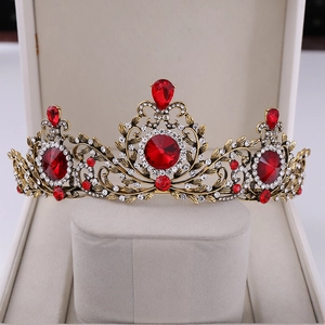Close-up of vintage baroque crown with red gemstones and leaf-patterned bronze metal