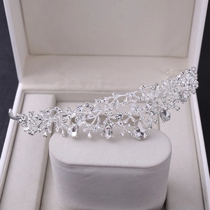 Macro shot of silver wedding tiara with crystal teardrops and intricate flower patterns