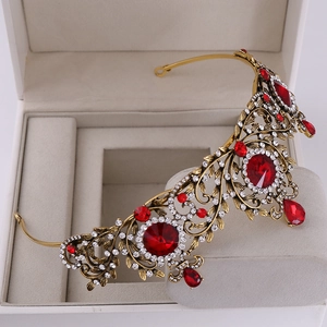 Close-up of vintage golden leaf crown with red gemstones and sparkling white crystals