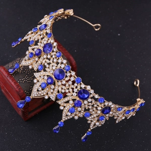 Detail of baroque bridal crown featuring blue crystals and golden floral metalwork
