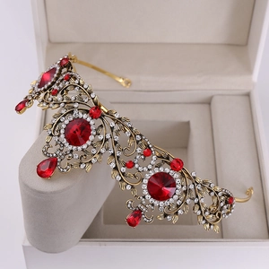 Vintage Baroque gold leaf bridal crown with red gems and crystal accents on display