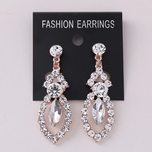 Macro view of rose gold long drop earrings featuring white rhinestones and marquise cut gem