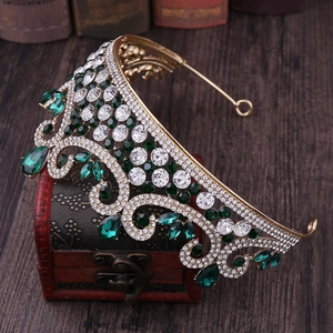 Détails d'une couronne de mariée vintage dorée avec gemmes vertes et cristaux blancs