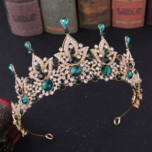 Detailed close-up of a vintage baroque gold crown featuring emerald crystals and rhinestones