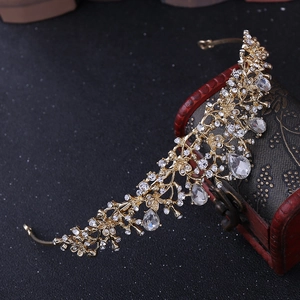 Close-up of golden floral bridal tiara with rhinestones and teardrop crystal pendants