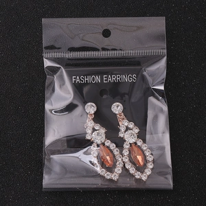 Macro view of pear-cut amber gemstones set in rose gold pavé rhinestone earrings