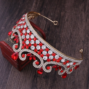 Vue détaillée de la couronne de mariée dorée avec strass rouges sur boîte en bois vintage