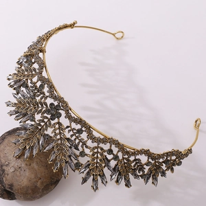 Close-up of vintage bridal tiara with grey crystals and antique gold leaf details