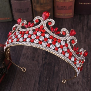 Détail d'une couronne baroque dorée avec gemmes rouges en goutte et strass brillants