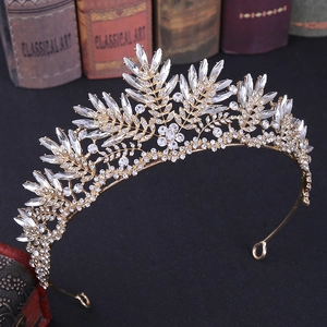 Detailed view of a golden crystal bridal crown with floral leaf patterns and elegant finish