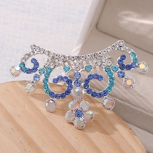 Vue détaillée d'un peigne couronne en strass avec des motifs en filigrane bleu et argent