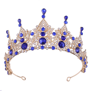 Detail of baroque gold crown featuring intricate filigree and deep blue teardrop crystals