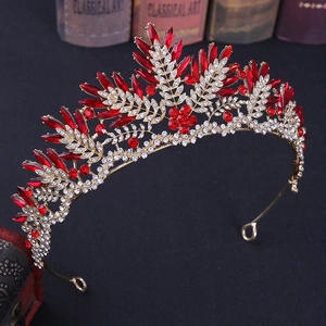 Close-up of red crystals and white rhinestones on a gold baroque bridal crown