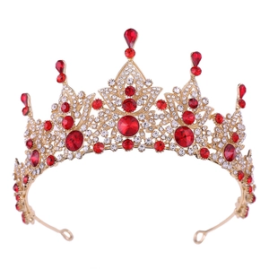Close-up of Baroque bridal crown featuring vintage gold finish and red teardrop crystals