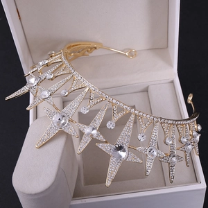 Macro shot of gold star-shaped bridal tiara with sparkling rhinestones in a white gift box