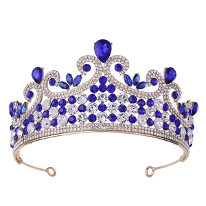 Détail de la couronne royale dorée avec pierres bleues en goutte et strass blancs