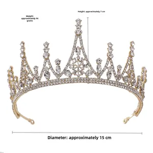 Detail view of gold baroque crown featuring clear rhinestones and zircon on white background