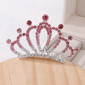 Sparkling pink rhinestone princess crown hair comb on wooden stand for children