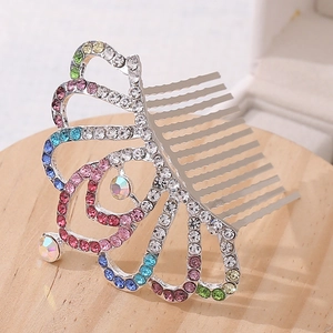 Detail of a silver hair comb with colorful rhinestones and butterfly crown design