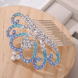 Detailed macro view of heart crystal crown hair comb with blue and silver gradient rhinestones