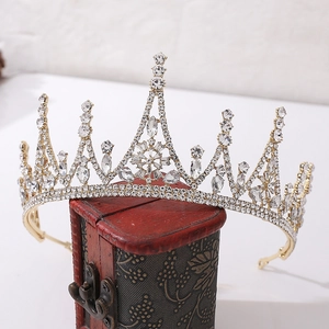 Close-up of golden Baroque bridal tiara with crystals on a vintage red jewelry box