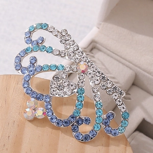 Detailed close-up of a crystal rhinestone tiara hair comb with blue heart and butterfly motifs