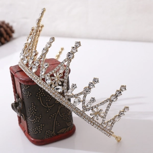 Detail of golden Baroque crown with clear rhinestones on a red vintage jewelry box