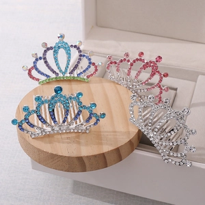 Detail of colorful rhinestone tiara hair combs for girls on a wooden display stand