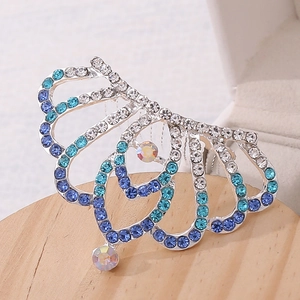 Detailed macro view of a silver crown hair comb with gradient blue and white rhinestones