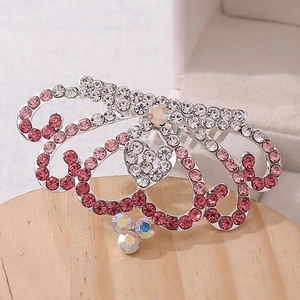 Macro shot of silver alloy hair comb with pink heart-shaped crystal rhinestones for kids