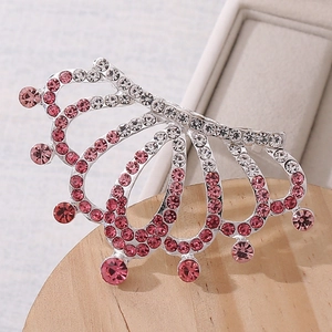 Detail of princess crown hair comb with pink rhinestones on a wooden display stand