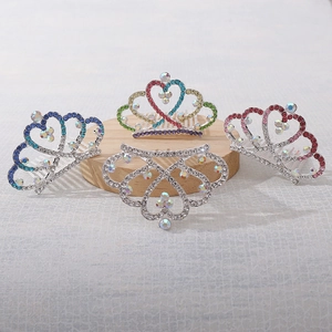 Dettaglio macro di quattro pettini per capelli a corona a cuore con strass colorati