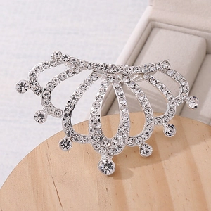 Close-up of sparkling crystal crown hair comb with silver alloy base on wooden tray