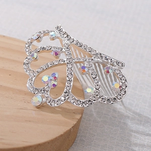 Dettaglio del pettine a corona a forma di cuore argento con strass colorati su legno