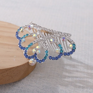 Dettaglio di un pettine per capelli a corona argento con strass blu e trasparenti brillanti