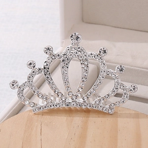Detailed view of silver crystal tiara hair comb resting on a jewelry display tray