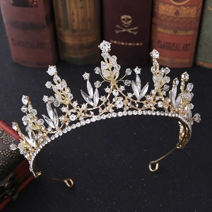 Detailaufnahme einer goldenen Brautkrone mit Kristallen auf einem Retro-Buch