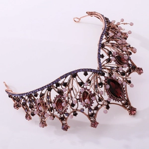 Close-up of gothic baroque crown with rose gold filigree and deep purple crystals